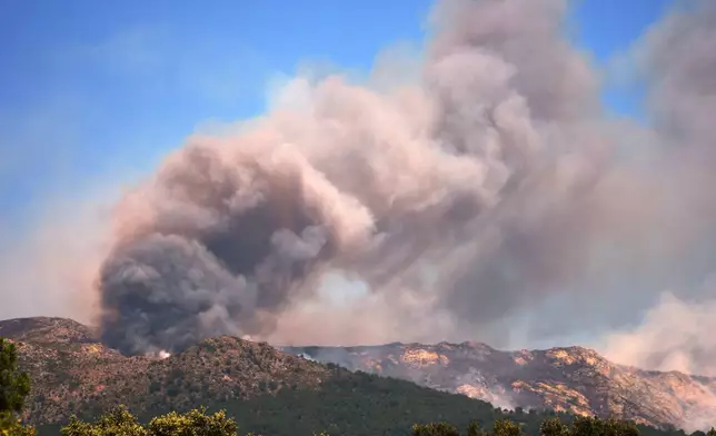 Smoke and flames rise as a wildfire advances near La Adrada, Ávila province, Spain, Friday, July 24, 2026. (AP Photo/Manu Fernandez)