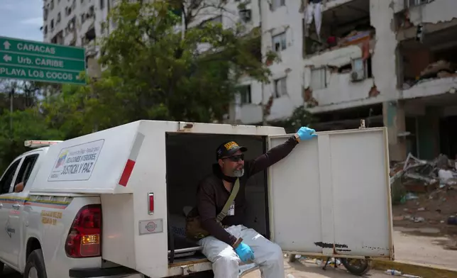 Forensic technician Joel Mirabal rides through the area struck by the earthquakes collecting bodies recovered from the rubble in La Guaira, Venezuela, Tuesday, June 30, 2026. (AP Photo/Matias Delacroix)