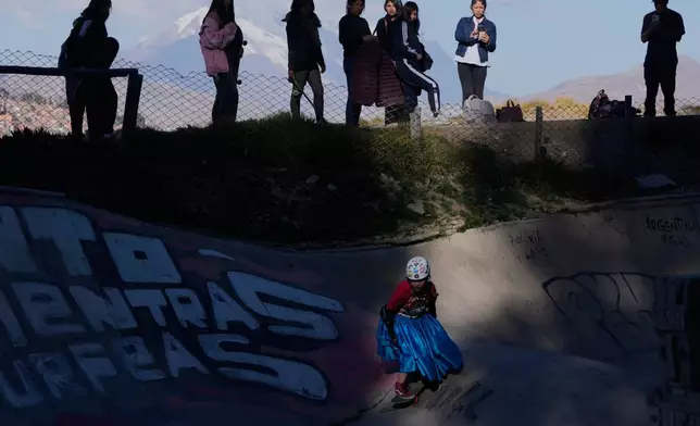Miriam Fernandez, wearing a traditional Cholita skirt, known as a pollera, rides her skateboard during a youth talent show in La Paz, Bolivia, Thursday, July 16, 2026. (AP Photo/Juan Karita)