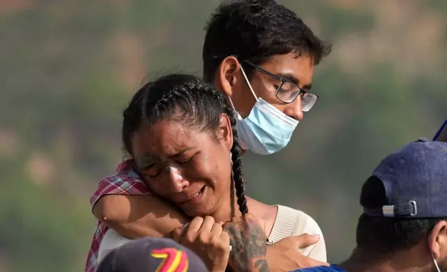 Yolimar Torres, left, cries after she and other family members found her daughter's body, which they recovered themselves from the rubble of a building collapsed by the earthquake in La Guaira, Venezuela, Wednesday, July 15, 2026. (AP Photo/Ariana Cubillos)