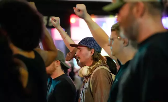 Attendees gesture during a candlelight vigil where a Madison police officer shot and killed a man Wednesday, July 22, 2026, in Madison, Wis. (AP Photo/Kayla Wolf)