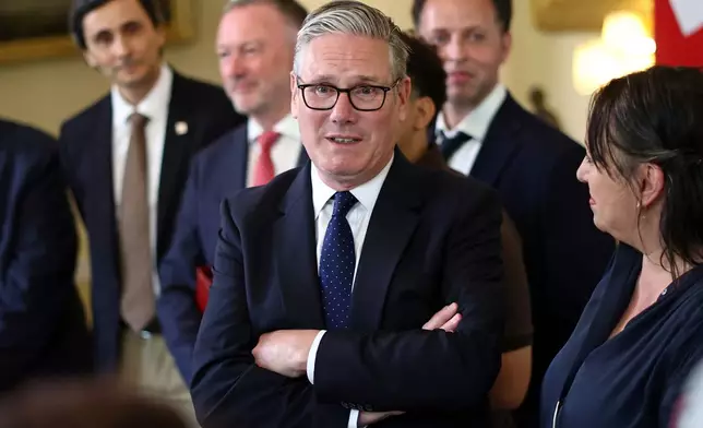 Britain's Prime Minister Keir Starmer, center, speaks with people whose lives who are said to have been improved by the Labour Government, during a meeting inside 10 Downing Street, central London, Wednesday July 15, 2026. (Henry Nicholls/Pool Photo via AP)