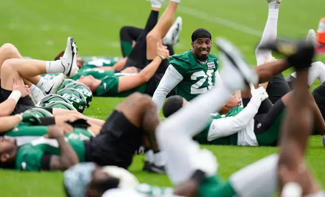 New York Jets' Breece Hall smiles while stretching during an NFL football training camp in Florham Park, N.J., Wednesday, July 29, 2026. (AP Photo/Seth Wenig)