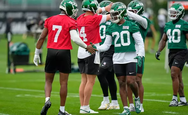 New York Jets' Breece Hall (20), center right, greets quarterback Geno Smith (7) during an NFL football training camp in Florham Park, N.J., Wednesday, July 29, 2026. (AP Photo/Seth Wenig)