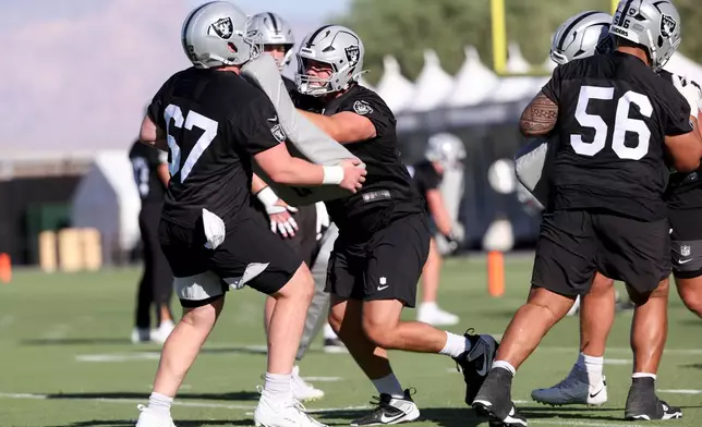 Las Vegas Raiders center Tyler Linderbaum (65) blocks center Will Putnam (67) during a drill during practice at the team's NFL football training camp, Thursday, July 30, 2026, in Henderson, Nev. (AP Photo/Ian Maule)