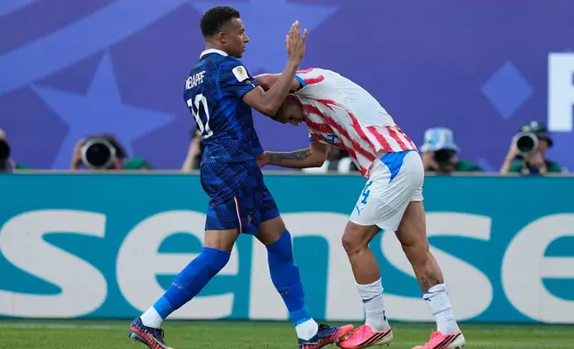 France's Kylian Mbappe, left, and Paraguay's Juan Jose Caceres scuffle during a World Cup round of 16 soccer match in Philadelphia, Saturday, July 4, 2026. (AP Photo/Matt Slocum)