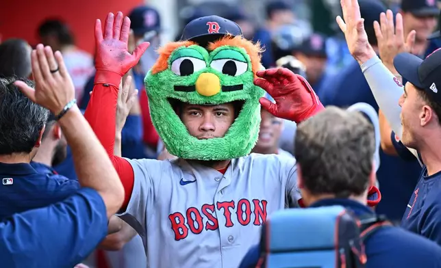 Boston Red Sox's Willson Contreras is greeted by teammates after hitting a three-run home run during the third inning of a baseball game against the Los Angeles Angels, Sunday, July 5, 2026, in Anaheim, Calif. (AP Photo/William Liang)