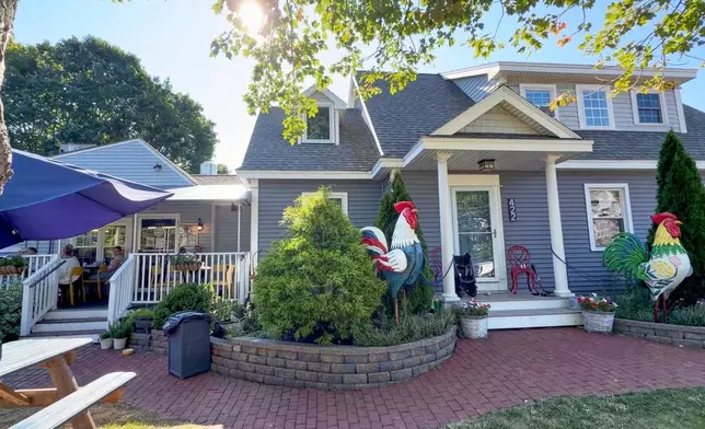 Large tin roosters decorate the entrance to the home of David and Sarah Leblanc, which is attached to their breakfast restaurant, The Omelette Factory, at left, in Ogunquit, Maine, Wednesday, July 22, 2026. (AP Photo/Robert F. Bukaty)
