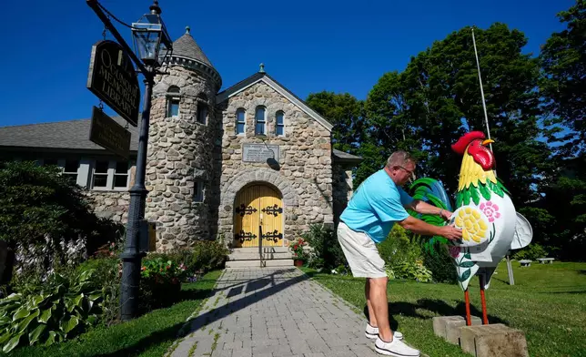 David LeBlanc sets up a rooster in front of the Memorial Library in Ogunquit, Maine, Thursday, July 23, 2026. (AP Photo/Robert F. Bukaty)
