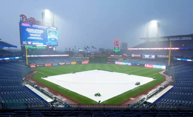 A tarp covers the field as rain falls, delaying the start of the baseball game between the Los Angeles Dodgers and the Philadelphia Phillies, Tuesday, July 21, 2026, in Philadelphia. (AP Photo/Chris Szagola)