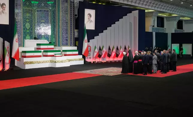 Iranian religious leaders and other mourners pay their respects before the coffins of slain Iranian Supreme Leader Ayatollah Ali Khamenei and members of his family during a viewing ceremony ahead of the dayslong funeral ceremonies at the Imam Khomeini Mosalla Grand Mosque in Tehran, Iran, Friday, July 3, 2026. (AP Photo/Vahid Salemi)