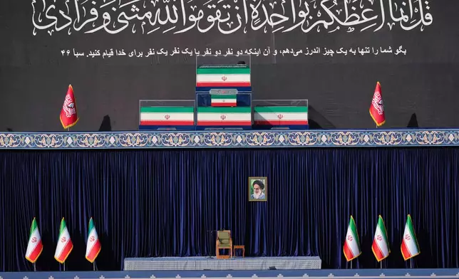 The coffins of slain Iranian Supreme Leader Ayatollah Ali Khamenei and members of his family are displayed on a platform above an empty chair at the start of the dayslong funeral ceremonies at the Imam Khomeini Mosalla Grand Mosque in Tehran, Iran, Saturday, July 4, 2026. (AP Photo/Altaf Qadri)