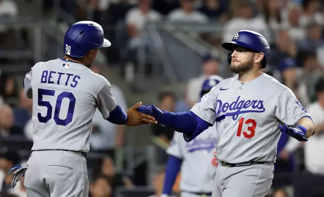Los Angeles Dodgers' Max Muncy (13) celebrates after his two-run home run with Mookie Betts (50) during the seventh inning of a baseball game against the New York Yankees, Friday, July 17, 2026, in New York. (AP Photo/Adam Hunger)