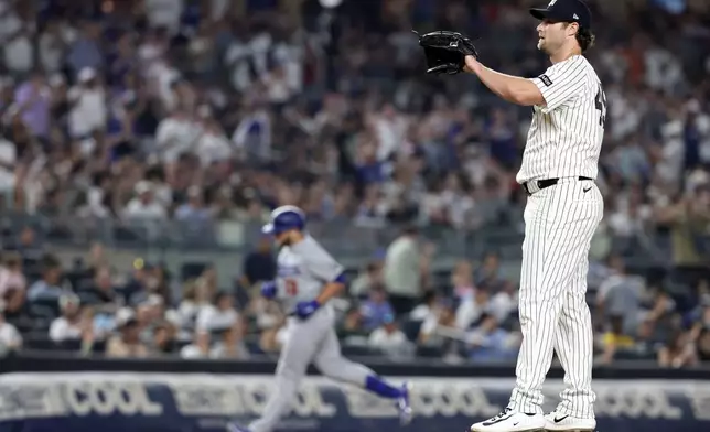 New York Yankees pitcher Gerrit Cole, right, reacts after giving up a two-run home run to Los Angeles Dodgers' Max Muncy during the seventh inning of a baseball game Friday, July 17, 2026, in New York. (AP Photo/Adam Hunger)