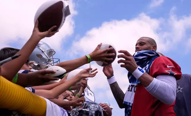 Dallas Cowboys quarterback Dak Prescott signs autographs during the NFL football team's training camp, Wednesday, July 29, 2026, in Oxnard, Calif. (AP Photo/Mark J. Terrill)