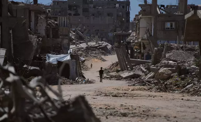 A Palestinian child walks along a street surrounded by buildings destroyed in Israeli military strikes during the Israel-Hamas war in Khan Younis, Gaza Strip, Wednesday, July 1, 2026. (AP Photo/Abdel Kareem Hana)