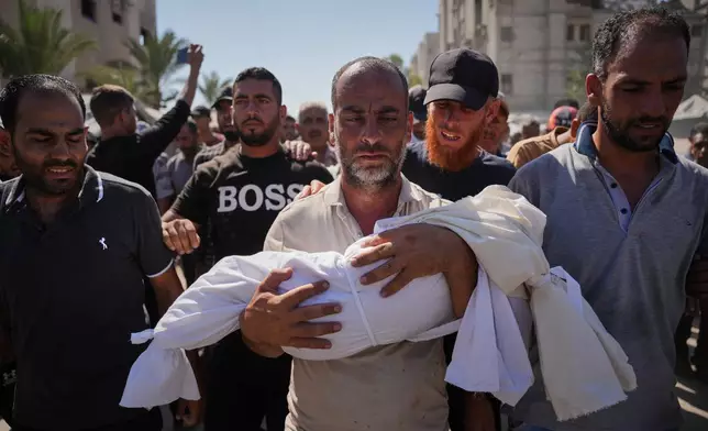 Thaer Abu Daraz carries the body of his infant daughter, Sewar, who was killed along with her mother in an Israeli airstrike that struck a tent camp for displaced Palestinians in Khan Younis, Gaza Strip, Tuesday, June 30, 2026. (AP Photo/Abdel Kareem Hana)