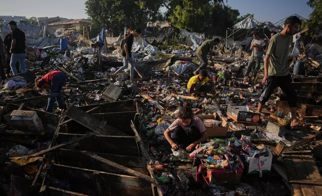 Palestinians collect food from the wreckage of their tents following an Israeli airstrike in Khan Younis, Gaza Strip, Tuesday, June 30, 2026. (AP Photo/Abdel Kareem Hana)