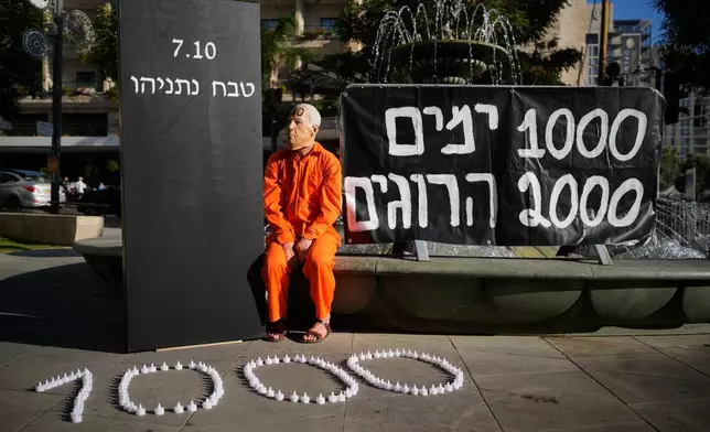 A demonstrator wearing a mask depicting Israeli Prime Minister Benjamin Netanyahu during a protest marking 1,000 days since the Oct. 7, 2023, Hamas-led attack on Israel, in Jerusalem, Thursday, July 2, 2026. (AP Photo/Ohad Zwigenberg)