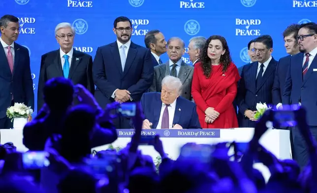 FILE - President Donald Trump signs the charter of his Board of Peace initiative at the Annual Meeting of the World Economic Forum in Davos, Switzerland, Jan. 22, 2026. (AP Photo/Markus Schreiber, File)