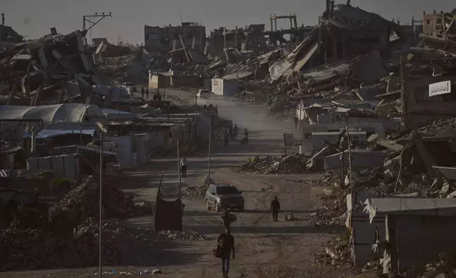 Palestinians walk along a road surrounded by buildings destroyed in Israeli military strikes during the Israel-Hamas war, in Jabaliya, Gaza Strip, Thursday, July 2, 2026. (AP Photo/Jehad Alshrafi)