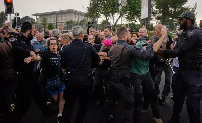 Police disperse demonstrators during a protest marking 1,000 days since the Oct. 7 2003 Hamas-led attack on Israel, outside of the Knesset, Israel's parliament, in Jerusalem, Thursday, July 2, 2026. (AP Photo/Ohad Zwigenberg)