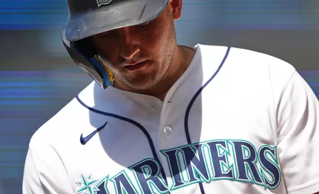 Seattle Mariners' Dominic Canzone walks back to the dugout after grounding out during the eighth inning of a baseball game against the Cincinnati Reds, Wednesday, July 22, 2026, in Seattle. (AP Photo/Lindsey Wasson)