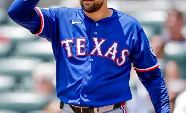 Texas Rangers pitcher Nathan Eovaldi reacts between Atlanta Braves batters during the first inning of a baseball game, Sunday, July 19, 2026, in Atlanta. (AP Photo/Erik S. Lesser)