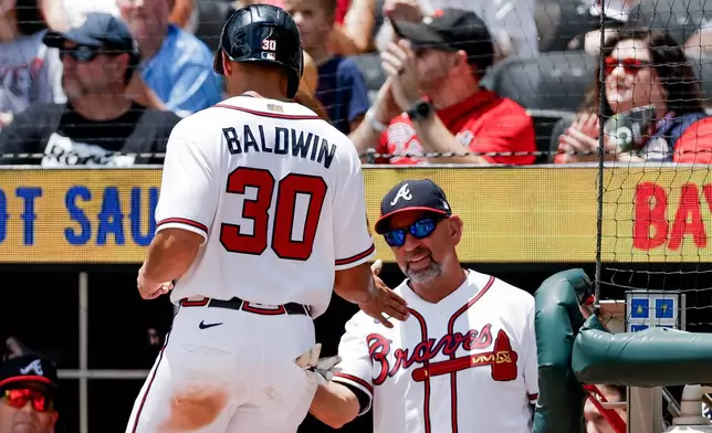 Atlanta Braves' Drake Baldwin (30) is greeted by manager Walt Weiss, right, after scoring against the Texas Rangers during the first inning of a baseball game, Sunday, July 19, 2026, in Atlanta. (AP Photo/Erik S. Lesser)