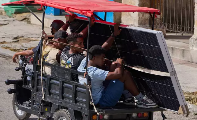 People transport solar panels on an electric tricycle in Havana, Cuba, Friday, July 10, 2026. (AP Photo/Ramon Espinosa)