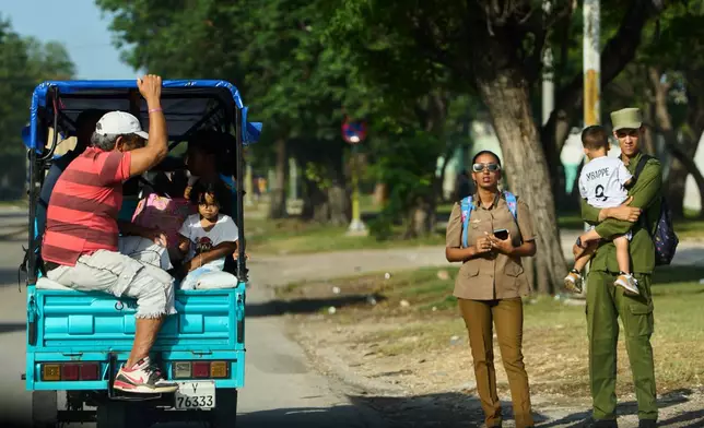 People ride in an electric tricycle in Havana, Cuba, Friday, July 10, 2026. (AP Photo/Ramon Espinosa)