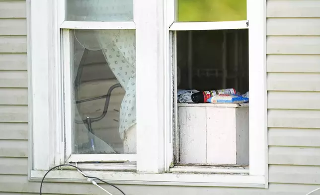 A bag of rice and a can of insect killer sit in an open window of a home where authorities say they removed 16 children and arrested four adults in Hamden, Ohio, Wednesday, July 1, 2026. (AP Photo/Carolyn Kaster)