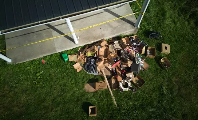 Debris is strewn on the front lawn of a home where authorities say they removed 16 children and arrested four adults in Hamden, Ohio, Wednesday, July 1, 2026. (AP Photo/Carolyn Kaster)