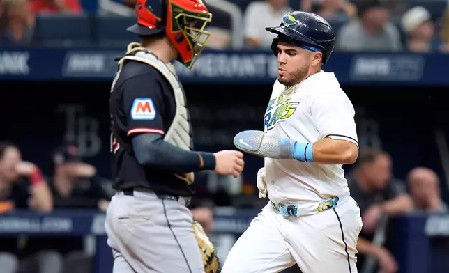 Tampa Bay Rays' Jonathan Aranda, right, scores in front of Cleveland Guardians catcher Patrick Bailey on a sacrifice fly by Cedric Mullins during the fifth inning of a baseball game Saturday, July 25, 2026, in St. Petersburg, Fla. (AP Photo/Chris O'Meara)