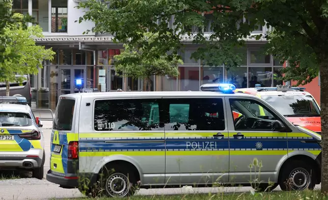 Police vehicles are parked in front of the Welfen High School, Schongau, Germany, Wednesday, July 8, 2026. (Karl-Josef Hildenbrand/dpa via AP)