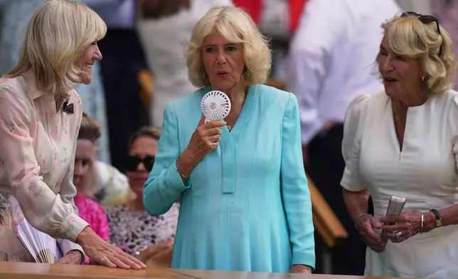 Britain's Queen Camilla uses a handheld fan to cool herself down as she sits in the royal box on day 10 of the Wimbledon Tennis Championships in London, Wednesday, July 8, 2026. (AP Photo/Brian Inganga)