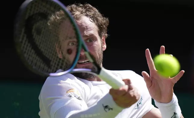 Roman Saffiulin of Russia returns the ball to Novak Djokovic of Serbia in their fourth round men's singles match at the Wimbledon Tennis Championships in London, Sunday, July 5, 2026. (AP Photo/Brian Inganga)