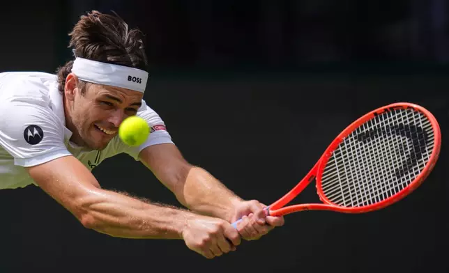 Taylor Fritz of the United States returns the ball to Dusan Lajovic of Serbia in their first round men's singles match at the Wimbledon Tennis Championships in London, Tuesday, June 30, 2026. (AP Photo/Kirsty Wigglesworth)