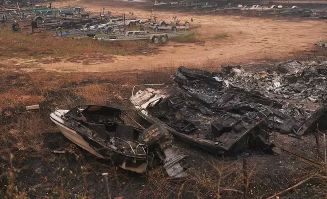 Recreational boats destroyed by a wildfire sit in Pelayos de la Presa, Madrid province, Spain, Tuesday, July 28, 2026. (AP Photo/Manu Fernandez)