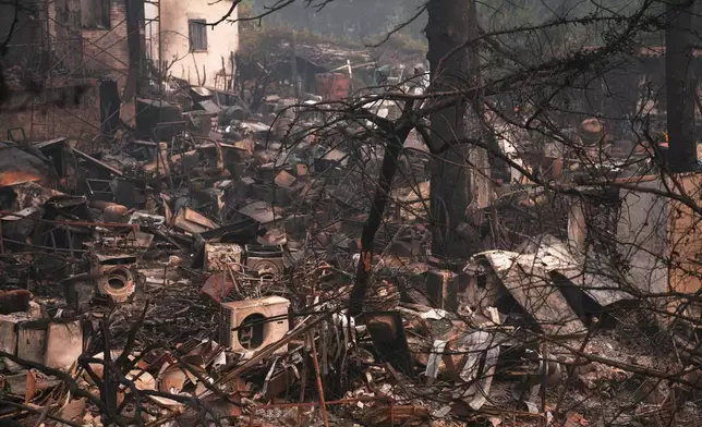A house and belongings destroyed by a wildfire are photographed as the fire continues to spread near Pelayos de la Presa, Madrid province, Spain, Tuesday, July 28, 2026. (AP Photo/Manu Fernandez)