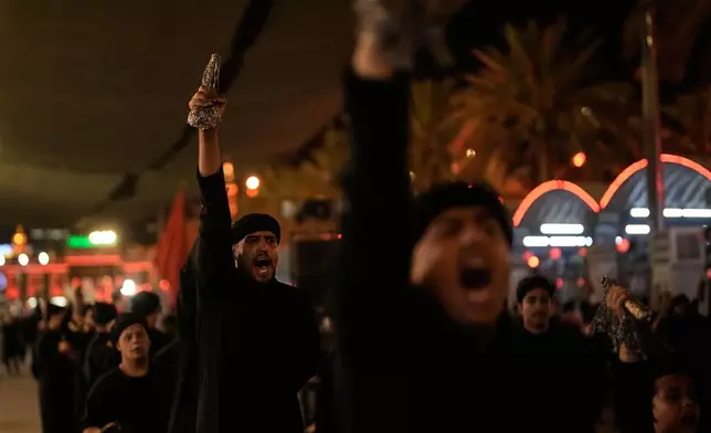 Shiite mourners chant slogans as the perform ritual self-flagellation with chains outside the Imam Hussein Shrine on the eve of funeral ceremonies for the late Iranian Supreme Leader Ayatollah Ali Khamenei in Karbala, Iraq, Tuesday, July 7, 2026. (AP Photo/Khalil Hamra)
