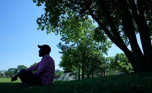 Neighborhood resident Yusuf Usim sits in the shade at Peavey Park during an extreme heat warning Monday, July 13, 2026, in Minneapolis. (AP Photo/Ellen Schmidt)