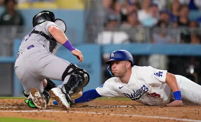 Los Angeles Dodgers' Dalton Rushing, right, is tagged out by Colorado Rockies catcher Braxton Fulford as he tries to score on a fielder's choice bunt by Miguel Rojas during the fifth inning of a baseball game Tuesday, July 7, 2026, in Los Angeles. (AP Photo/Mark J. Terrill)