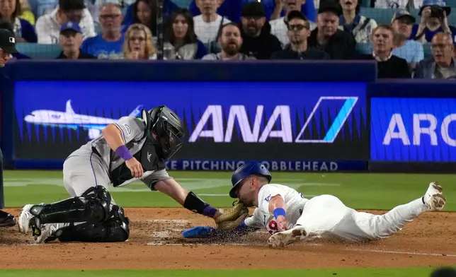 Los Angeles Dodgers' Dalton Rushing, right, is tagged out by Colorado Rockies catcher Braxton Fulford as he tries to score on a fielder's choice bunt by Miguel Rojas during the fifth inning of a baseball game Tuesday, July 7, 2026, in Los Angeles. (AP Photo/Mark J. Terrill)