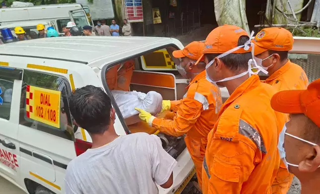 Rescue workers carry the body of a victim into an ambulance outside the entrance to an under-construction tunnel at a hydropower project in Samardung village, about 40 kilometers (25 miles) from Gangtok, India, Tuesday, July 21, 2026. (AP Photo)