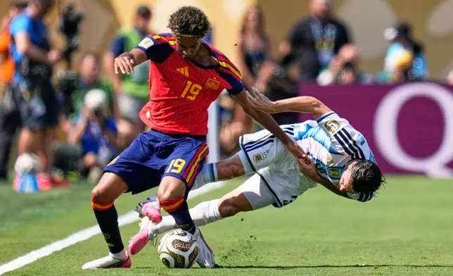 Argentina's Nicolas Tagliafico, right, fights for the ball with Spain's Lamine Yamal during the World Cup final soccer match between Spain and Argentina in East Rutherford, N.J., near New York, Sunday, July 19, 2026. (AP Photo/Ashley Landis)