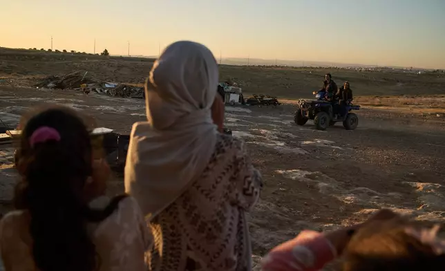 Palestinian girls watch Israeli settlers riding a quad bike past their community near the West Bank village of Susya, in the Masafer Yatta region, Wednesday, June 17, 2026.(AP Photo/Leo Correa)