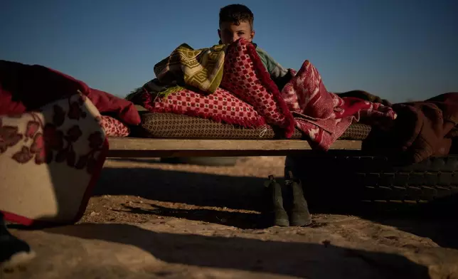 Yasser, 8, looks at the camera after taking a nap in the morning outside his house in a Palestinian community near the West Bank village of Susya, in the Masafer Yatta region, Thursday, June 18, 2026. (AP Photo/Leo Correa)