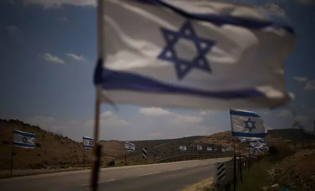 Israeli flags are seen lining a road in the northern Jordan Valley in the occupied West Bank, Wednesday, June 24, 2026. (AP Photo/Leo Correa)