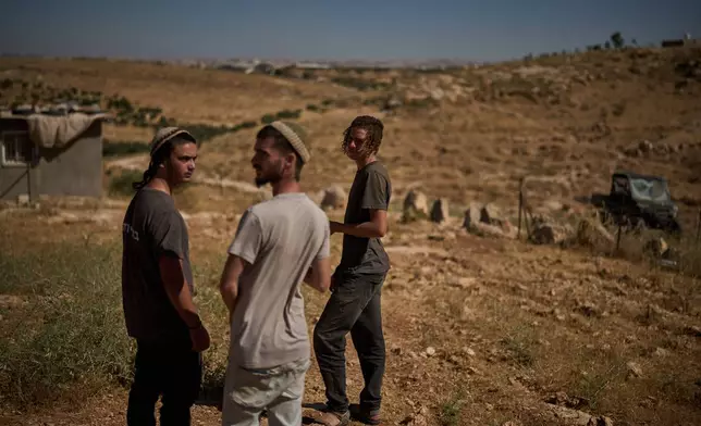 Israeli settlers stand together as they wait for the arrival of police after accusing Palestinians of setting a field on fire near the West Bank village of Susya, in the Masafer Yatta region, Thursday, June 18, 2026.(AP Photo/Leo Correa)